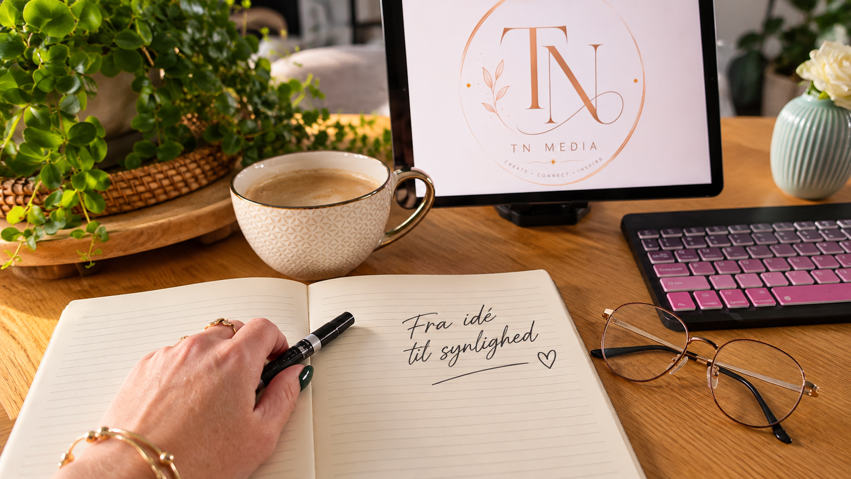 TN Media-logo, kaffekop, tablet og notesbog med teksten Fra idé til synlighed